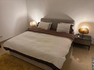 une chambre avec un grand lit avec deux lampes dans l'établissement Waterfront - B luxury, à Dakar 37 autres photos