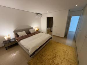 une chambre avec un grand lit et un tapis dans l'établissement Waterfront - B luxury, à Dakar