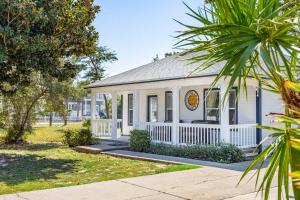 una pequeña casa blanca con una valla blanca en Emerald Escape-Crystal Beach-Private Pool-GolfCart, en Destin
