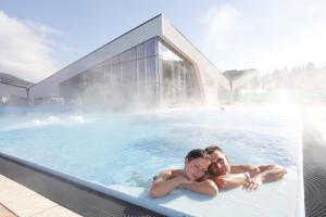 a man and a child in a swimming pool at Urlaubsland Sonnfeld in Flachau