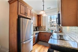 eine Küche mit Holzschränken und einem Edelstahlkühlschrank in der Unterkunft Romancing The Jones in Savannah