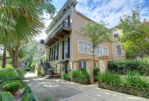 ein großes gelbes Haus mit Balkon und Bäumen in der Unterkunft Romancing The Jones in Savannah