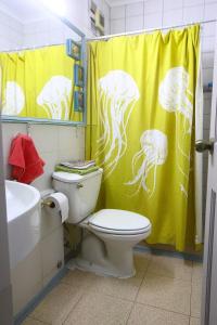 baño con aseo y cortina de ducha amarilla en 3-room apartment steps from Los Dominicos, en Santiago
