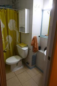baño con aseo y cortina de ducha amarilla en 3-room apartment steps from Los Dominicos, en Santiago