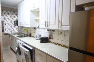 a kitchen with white cabinets and a sink at 3-room apartment steps from Los Dominicos in Santiago +16 photos