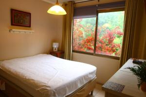 a bedroom with a white bed and a window at 3-room apartment steps from Los Dominicos in Santiago