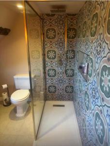 a bathroom with a toilet and a glass shower stall at The Grange, Northill in Northill