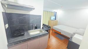 a bathroom with a sink and a bed in a room at Studio Units near Airport by Jade Studio Apartments in Manila +32 photos