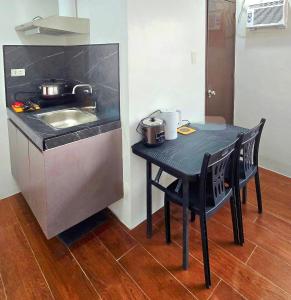 a small kitchen with a table and a sink at Studio Units near Airport by Jade Studio Apartments in Manila