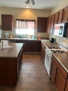 a kitchen with wooden cabinets and a white stove top oven at West Phoenix Value Room 4 Bennet in Phoenix