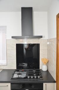 a person standing behind a stove in a kitchen at JMG HOUSE - Quality Rooms in West Bromwich