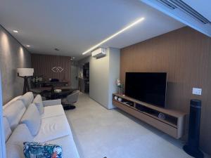 ein Wohnzimmer mit Couch und Flachbildfernseher in der Unterkunft Paraíso na Riviera São Lourenço - Laguna Home Resort in Riviera de São Lourenço