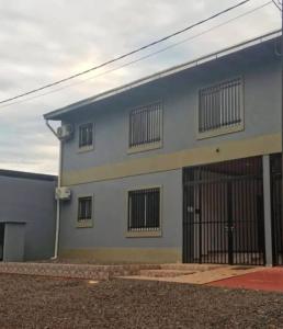 a blue and white building with barred windows at Departamentos por dia in Eldorado