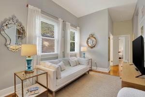 ein Wohnzimmer mit einem weißen Sofa und einem Fernseher in der Unterkunft Hideaway on Jones in Savannah