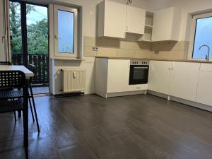 a kitchen with white cabinets and a table and chairs at Rodgau Work & Sleep in Rodgau