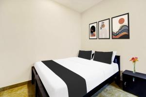1 dormitorio con 1 cama en blanco y negro con cuadros en la pared en Super Collection O Saravanampatti, en Coimbatore