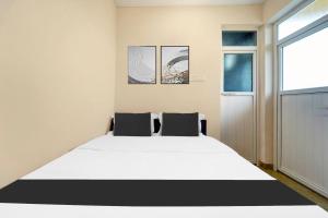 Un dormitorio con una cama blanca grande y una ventana en Super Collection O Saravanampatti, en Coimbatore 52 fotos más