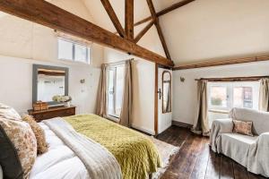une chambre avec un lit, une chaise et des fenêtres dans l'établissement Mulberry Coach House, à East Rudham