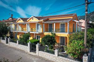 une maison jaune sur le côté d'une rue dans l'établissement Corfu Dream Fani, à Ýpsos