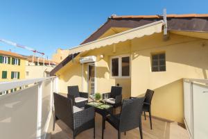 a patio with chairs and a table on a balcony at HomeHolidaySanremo - Luxe & Glamour in Sanremo