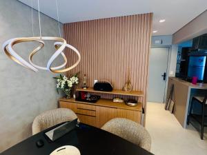 Zimmer mit einem Schreibtisch, 2 Stühlen und einem Kronleuchter in der Unterkunft Paraíso na Riviera São Lourenço - Laguna Home Resort in Riviera de São Lourenço + 36 Fotos