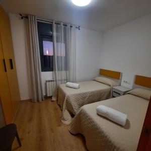 a hotel room with two beds and a window at Duplex LLORACH I in Omellóns