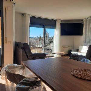 un salon avec une table et une grande fenêtre dans l'établissement Duplex LLORACH I, à Lleida