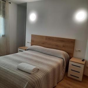 une chambre avec un grand lit et deux tables de nuit dans l'établissement Duplex LLORACH I, à Lleida