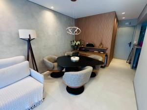 ein Wohnzimmer mit einem Tisch und einigen Stühlen in der Unterkunft Paraíso na Riviera São Lourenço - Laguna Home Resort in Riviera de São Lourenço
