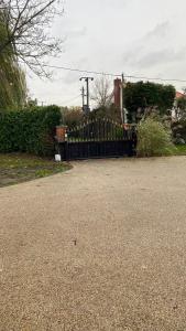a driveway with a wooden fence and a house at The cottage in Bury Saint Edmunds