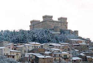a large building on a hill with snow covered buildings at Da nonna Maria in Celano