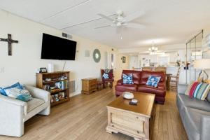 a living room with a couch and a tv at Amelia South Beach Condo in Fernandina Beach