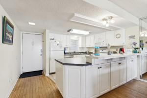 a kitchen with white cabinets and a white refrigerator at Amelia South Beach Condo in Fernandina Beach +31 photos