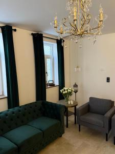 a living room with a couch and a chair and a chandelier at Break Time Holidays Königsee, ein Juwel im Thüringer Wald in Niederdorla