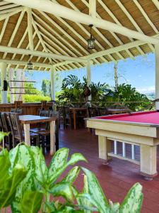 a patio with a pool table and tables and chairs at Linaje Salvaje Hotel in Calarcá