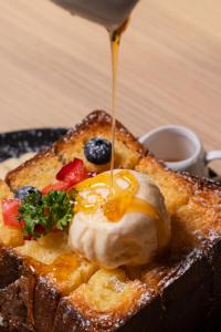 a piece of toast being drizzled with syrup at I Talay phuket in Ban Karon +28 photos
