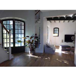 a living room with a couch and a tv at Villa Gustavine - Maison d'Architecte in Ger
