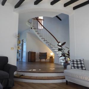 a living room with a staircase and a couch at Villa Gustavine - Maison d'Architecte in Ger +11 photos