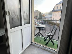 an open window with a table and a chair on a balcony at Pension Kaditz in Dresden +26 photos