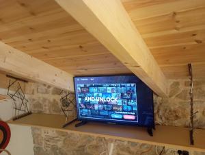 a television sitting on a shelf under a wooden ceiling at Casa dell'Arte Nafplio in Nafplio