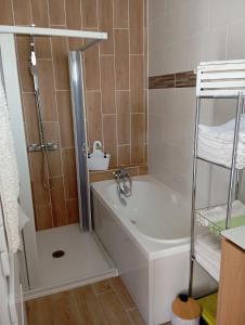 une salle de bain avec une douche, une baignoire et un lavabo dans l'établissement Le Haut de Clarques, à Clarques 19 autres photos