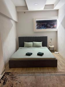 a bedroom with a large bed with two towels on it at Apartman Aleksandar 
