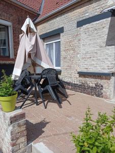 une table et des chaises avec un parasol sur une terrasse dans l'établissement Le Haut de Clarques, à Clarques