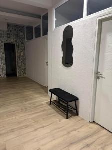 a bench next to a wall with a guitar on it at Apartman Aleksandar 
