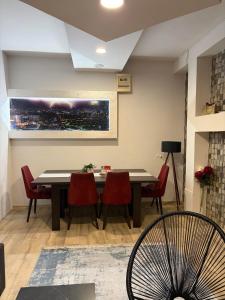 a dining room with a table and red chairs at Apartman Aleksandar 