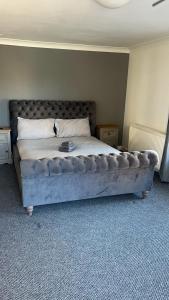 a bedroom with a large bed with a tufted headboard at Whole property in Kirkcaldy Fife in Fife