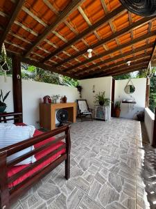 eine Terrasse mit Holzdach und einer Bank in der Unterkunft Casa Okê Paraty in Paraty