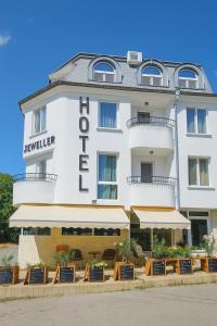 - un bâtiment blanc avec un panneau indiquant l'hôtel dans l'établissement Jeweller Hotel, à Ruse