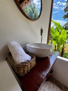 ein Badezimmer mit einem Waschbecken und einem Spiegel in der Unterkunft Casa Okê Paraty in Paraty