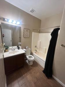 a bathroom with a sink and a toilet and a tub at West Valley King Room 94th in Phoenix +3 photos